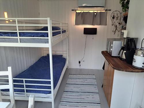 a small room with two bunk beds and a kitchen at Harmony in Farhult in Farhult