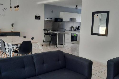 a living room with a couch and a table and a kitchen at La Maison LUDO in Arrest