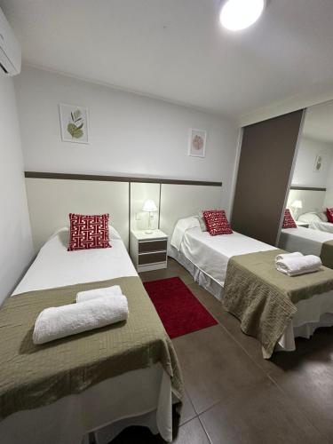Habitación de hotel con 2 camas con almohadas rojas en SOMBRAS DEL PARANA Apart Misiones en Eldorado