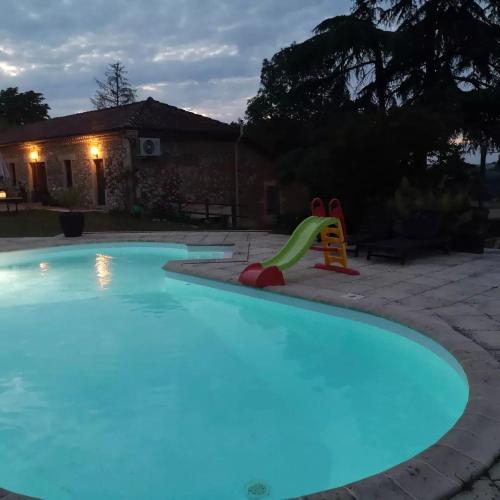 una piscina con un tobogán en un patio trasero en Les trois jolies, 