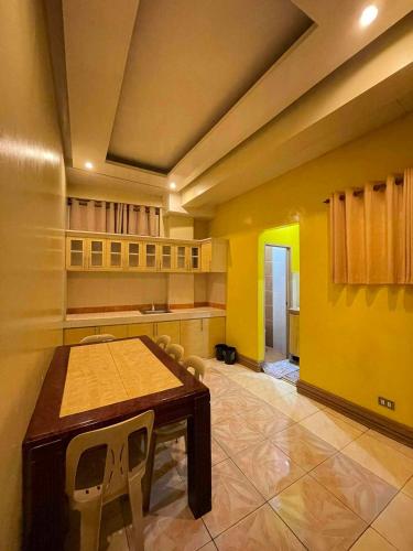 a large kitchen with a wooden table and chairs at ASHBURN'S TRANSIENT BAGUIO - 3rd to 5th floor BASIC SLEEP and GO Accommodation, WITH PARKING, NO ELEVATOR in Baguio