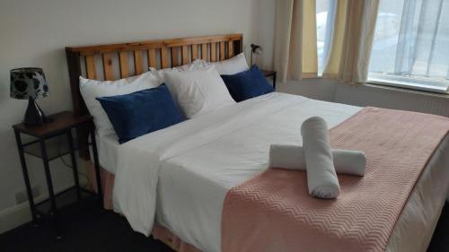 una camera da letto con un grande letto bianco con cuscini blu di Fair Oak Self-Catering Accomodation a Sandown