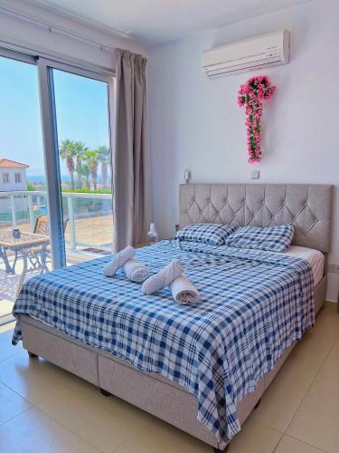 um quarto com uma cama com um cobertor azul e branco. em 3 Bedroom Coral Bay Beach Seaview Villa II Private Pool em Coral Bay
