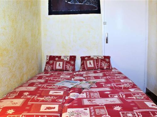 a bedroom with a bed with a red blanket and pillows at Appartement pieds des pistes, 2 cabines, 4 personnes - Risoul 1850 - FR-1-330-173 in Risoul