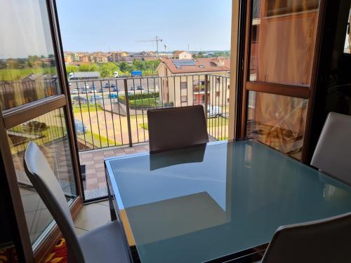 een glazen tafel en stoelen in een kamer met een raam bij Betulle 2G in Leinì