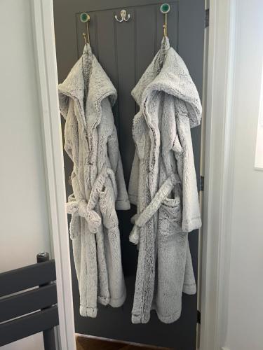 a group of white towels hanging on a door at Chloes Retreat in Norwich