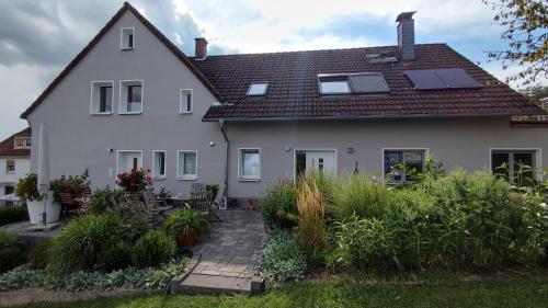 uma casa branca com painéis solares no telhado em Ferienwohnung Naumann em Schotten