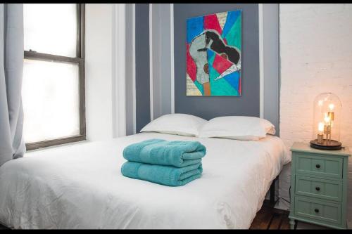 a white bed with blue towels on top of it at 4BR 10 mins walk to Central Park! in New York