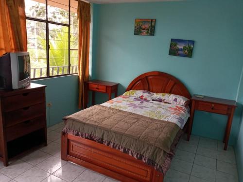a bedroom with a bed and a dresser and a tv at Zumag Sisa in Tena