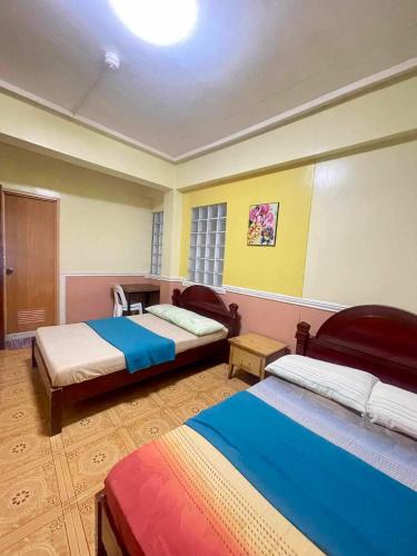 a room with two beds in a room at ASHBURN'S TRANSIENT BAGUIO - 3rd to 5th floor BASIC SLEEP and GO Accommodation, WITH PARKING, NO ELEVATOR in Baguio