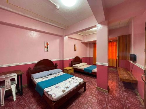 a room with two beds and a tv in it at ASHBURN'S TRANSIENT BAGUIO - 3rd to 5th floor BASIC SLEEP and GO Accommodation, WITH PARKING, NO ELEVATOR in Baguio