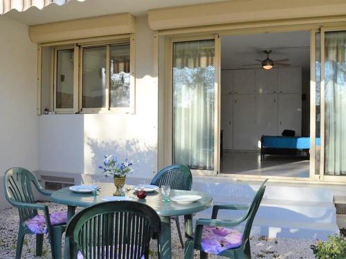 une table et des chaises assises sur une terrasse dans l'établissement Studio climatisé au Lavandou avec terrasse, parking et environnement calme - 3 couchages - FR-1-251-167, au Lavandou