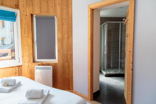 Cette chambre comprend un lit, un miroir et une salle de bains. dans l'établissement IMMODREAMS - Le Thelma, à Morzine