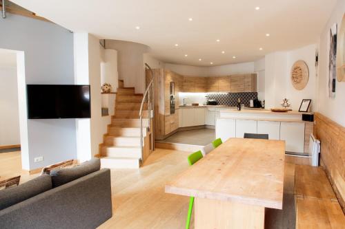 Il comprend une cuisine ouverte et un salon avec une table en bois. dans l'établissement IMMODREAMS - Le Thelma, à Morzine