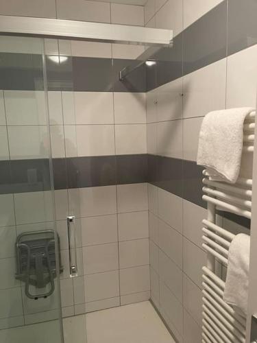 a bathroom with a shower with a mirror and towels at Champs Bernard in Villefranche-de-Rouergue
