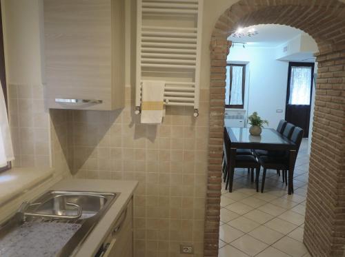 a kitchen with a sink and a table in a room at Appartamento QCM natura cultura e divertimento in Giulianello
