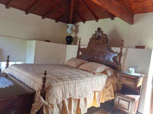 um quarto com uma cama grande e uma cabeceira em madeira em O cantinho da Laura em Lamego