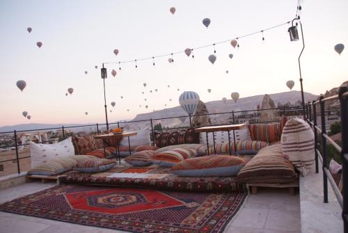 un patio con sofás y almohadas en un balcón en Peruna Cave en Göreme