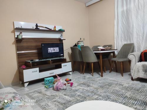 Ferienhaus Domizil في طرسوس: غرفة معيشة مع تلفزيون وطاولة مع كراسي