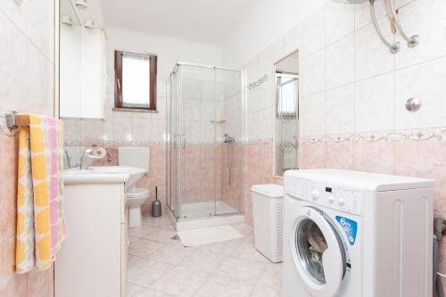 a washing machine in a bathroom with a shower at House Soni - 800 m from the sea in Rovinj