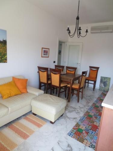 uma sala de estar com um sofá, uma mesa e cadeiras em Villa Murgese em Noci
