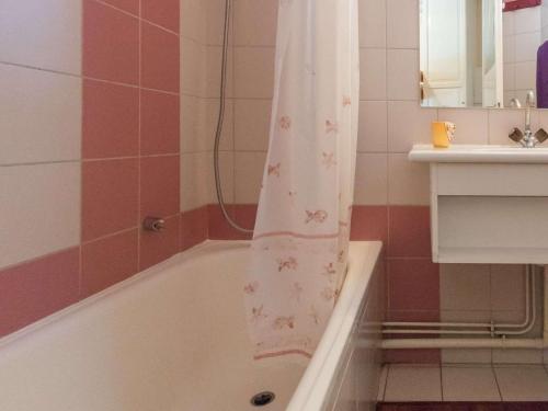 a bathroom with a bath tub with a shower curtain at Appartement Briançon, 1 pièce, 4 personnes - FR-1-330C-18 in Briançon