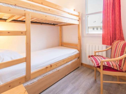 1 Schlafzimmer mit 2 Etagenbetten und einem Stuhl in der Unterkunft Appartement cosy avec balcon, parking privé et à 400m des télécabines – Centre-ville Briançon - FR-1-330C-19 in Briançon