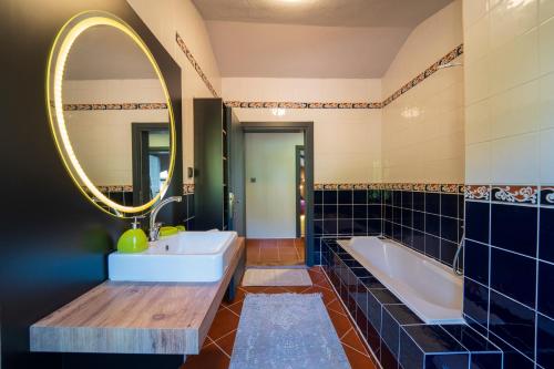 a bathroom with a tub and a sink and a mirror at Z Villa in Pırnaz