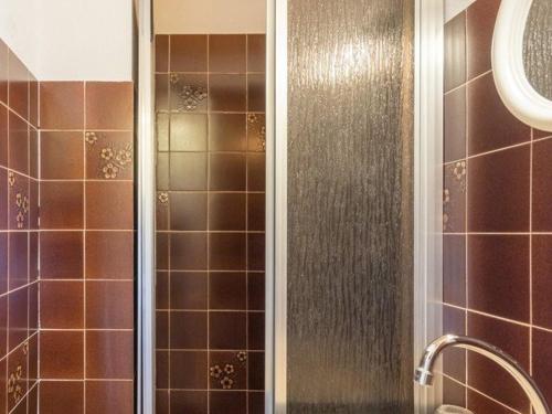 La salle de bains est pourvue d'une douche avec du carrelage brun. dans l'établissement Charmant T3 6 pers avec parking, proche pistes et centre - FR-1-330F-27, au Monêtier-les-Bains