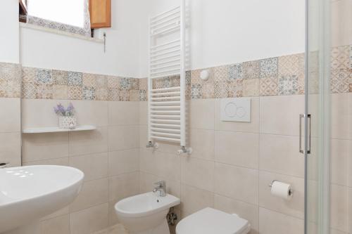 uma casa de banho branca com um WC e um lavatório em Kalos em Sorrento