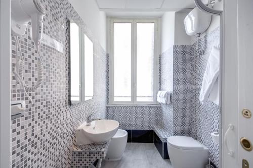 a white bathroom with a sink and a toilet at MF Hotel in Rome
