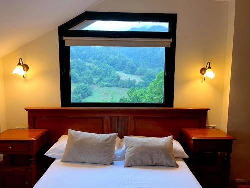 a bedroom with a large window above a bed at MIRADOR DE LAS UBIÑAS in Ríospaso