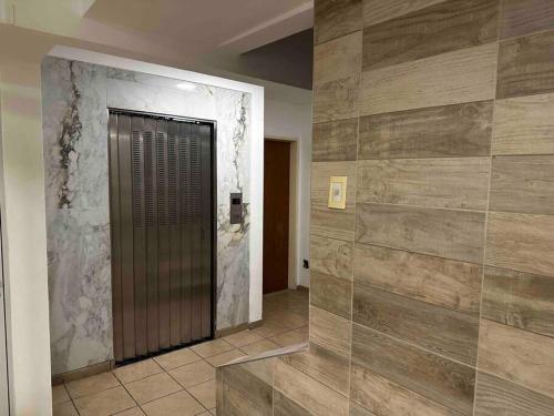 um corredor com uma porta de metal e uma parede de azulejos em San Lorenzo 3314 2piso ascensor em Rosário