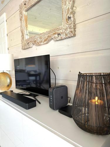 une télévision et un haut-parleur sur un comptoir avec un miroir dans l'établissement Jolie Maison Cosy Vue Golfe de Saint Tropez, à Gassin