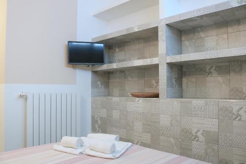 um quarto com toalhas e uma televisão numa parede em Gambara GuestS House em Milão