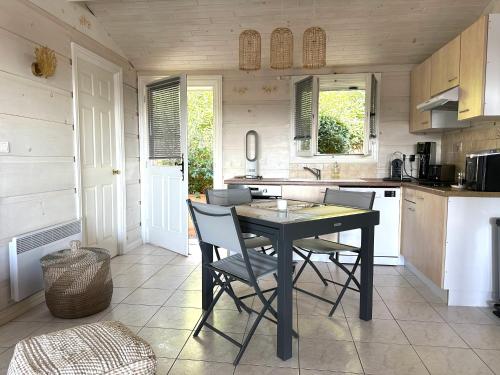 a kitchen with a black table and chairs in it at Jolie Maison Cosy Vue Golfe de Saint Tropez in Gassin