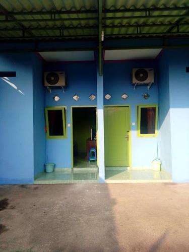 ein blaues Gebäude mit Türen und Lautsprechern in der Unterkunft Nafata Ajibarang 