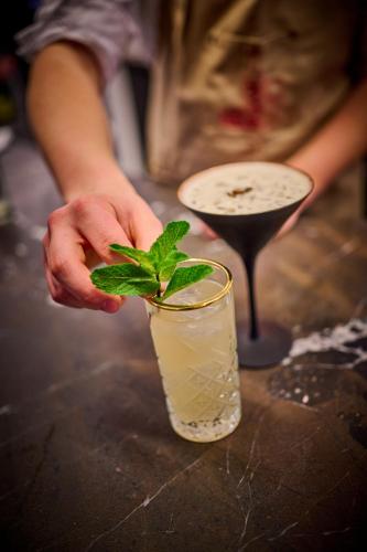 a person holding a green plant in a drink at Asam Hotel in Straubing