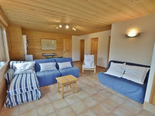 a living room with a blue couch and a table at Chalet Le Grand-Bornand, 7 pièces, 10 personnes - FR-1-391-19 in Le Grand-Bornand