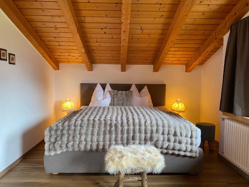 a bedroom with a large bed with two lamps at Ferienwohnungen Jägerheim & Jägerhaus in Ehrwald