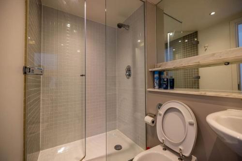 a bathroom with a shower and a toilet and a sink at IGM 2beds Property in London
