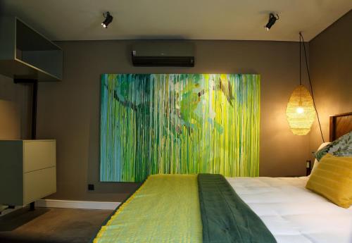a bedroom with a large painting on the wall at 1 On Royal in Cape Town