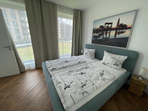 - une chambre dotée d'un lit avec un cadre bleu dans l'établissement Ferienwohnung Romeike "NewPort", à Bremerhaven