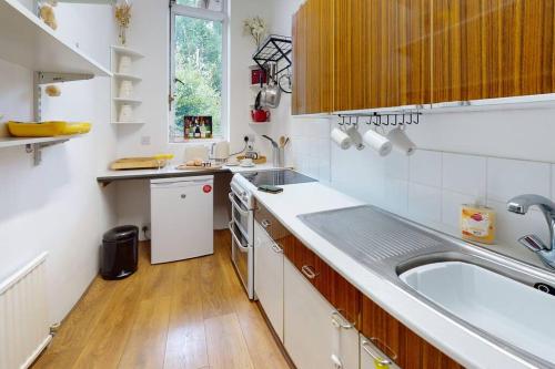 a small white kitchen with a sink and a counter at Spacious one bedroom flat in West Hoathley