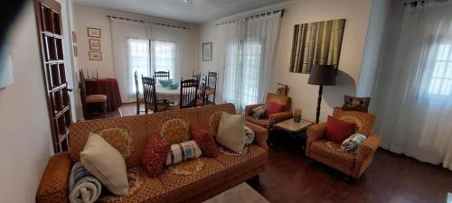 a living room with a couch and two chairs at Vivenda Alju in Ourém