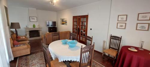 a dining room with a table and chairs and a living room at Vivenda Alju in Ourém