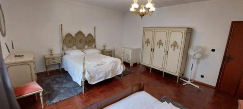 a bedroom with a bed and a dresser at Vivenda Alju in Ourém