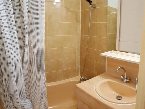 une salle de bain avec un rideau de douche et un lavabo dans l'établissement Charmant T2 avec Piscine et Parking Privé, Proche Plage et Centre, Argelès-sur-Mer - FR-1-388-88, à Argelès-sur-Mer