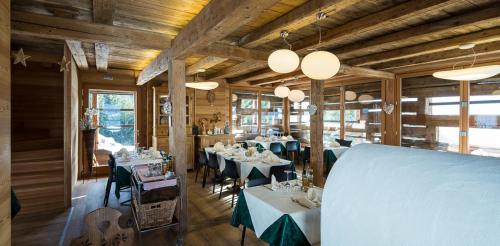 um restaurante com mesas e cadeiras num quarto em Agriturismo Botondoro em San Niccolò Comèlico