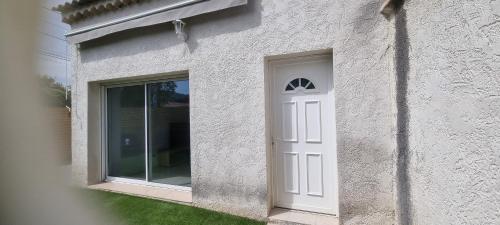 une porte blanche sur le côté d'une maison dans l'établissement aux creissauds, à Aubagne